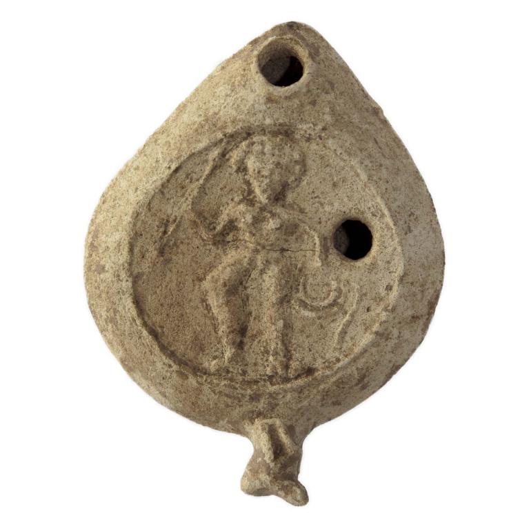 Homme nu, les pieds chaussés de sandales à lanières qui montent à mi-mollet. Sa chevelure volumineuse doit être crépue. Il porte dans la main droite un objet long et fin, semblable à une lance ou à un baton, que termine une croix. Sa main gauche repose sur la hanche, le coude est décollé du corps, sous sa main gauche un cercle et un serpentin difficiles à interpréter, bouclier ?. A droite et à gauche du personnage, deux grandes palmes Datation proposée: 500 / 700 Vor : Lafl 2005, type I; Lyon-Caen 1986, "Lampes en forme d'amande", variante a. - Oziol n° 829 - Alata çamligi (TR) (Lafl 2006, fig.2, a) LMP-5019 n° 20111210 001 Homme nu, les pieds chaussés de sandales à lanières qui montent à mi-mollet. Sa chevelure volumineuse doit être crépue. Il porte dans la main droite un objet long et fin, semblable à une lance ou à un baton, que termine une croix. Sa main gauche repose sur la hanche, le coude est décollé du corps, sous sa main gauche un cercle et un serpentin difficiles à interpréter, bouclier ?. A droite et à gauche du personnage, deux grandes palmes Datation proposée: 500 / 700 Vor : Lafl 2005, type I; Lyon-Caen 1986, "Lampes en forme d'amande", variante a. - Oziol n° 829 - Alata çamligi (TR) (Lafl 2006, fig.2, a) LMP-5019 n° 20111210 001