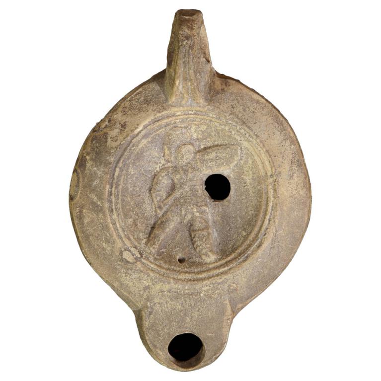 Gladiateur un secutor portant en l'air son bouclier du bras gauche, et du droit son glaive court (scutum). Sa tête est protégée par un casque à visière sans rebord surmonté d'une grande crête arrondie. Sa jambe gauche est protégée par une jambière (ocrea). Son adversaire unique est le rétiaire. L'attitude de ce secutor avec son bouclier en l'air semble signifier sa victoire. D. 109 x 74 x 28 mm Signature MNOVIVST Identique Dejean n° M445 Acquisition SVV Labarbe Marc 20121125 039 Gladiateur un secutor portant en l'air son bouclier du bras gauche, et du droit son glaive court (scutum). Sa tête est protégée par un casque à visière sans rebord surmonté d'une grande crête arrondie. Sa jambe gauche est protégée par une jambière (ocrea). Son adversaire unique est le rétiaire. L'attitude de ce secutor avec son bouclier en l'air semble signifier sa victoire. D. 109 x 74 x 28 mm Signature MNOVIVST Identique Dejean n° M445 Acquisition SVV Labarbe Marc 20121125 039