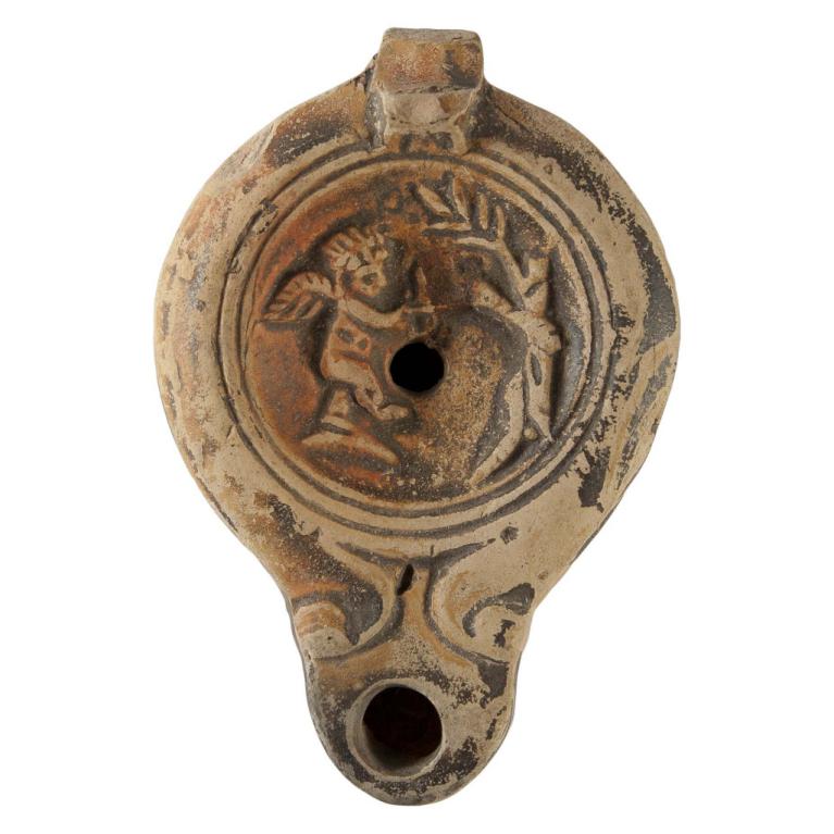 Cupidon, Éros, à gauche, armé d'un arc, décoche une flèche sur un serpent lové autour d'un tronc d'arbre à droite. Signature de potier CCLO.SVC Ex collection GV Voir fiche N° 20130613 039 Cupidon, Éros, à gauche, armé d'un arc, décoche une flèche sur un serpent lové autour d'un tronc d'arbre à droite. Signature de potier CCLO.SVC Ex collection GV Voir fiche N° 20130613 039